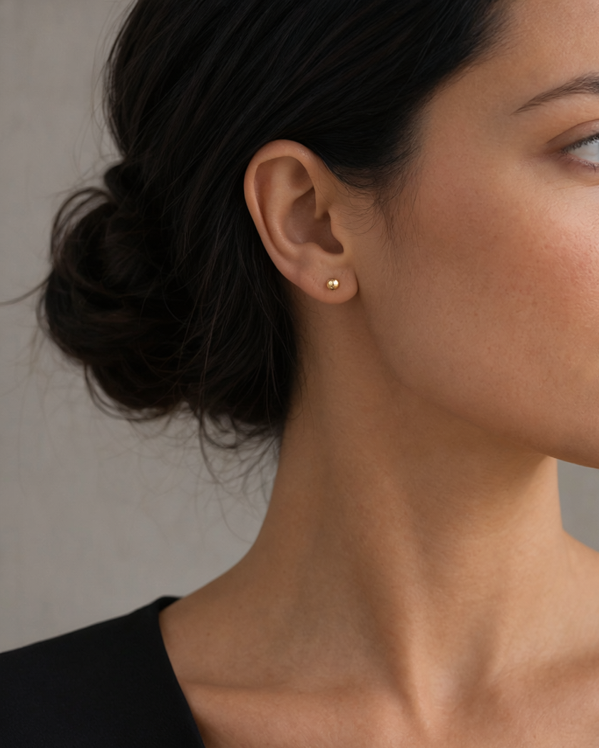 The One Studs vergoldet als Ohrstecker am Model getragen